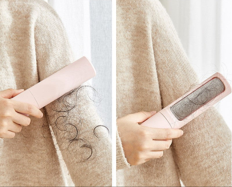 Person using a pink pet hair remover on a beige sweater with hair being removed.